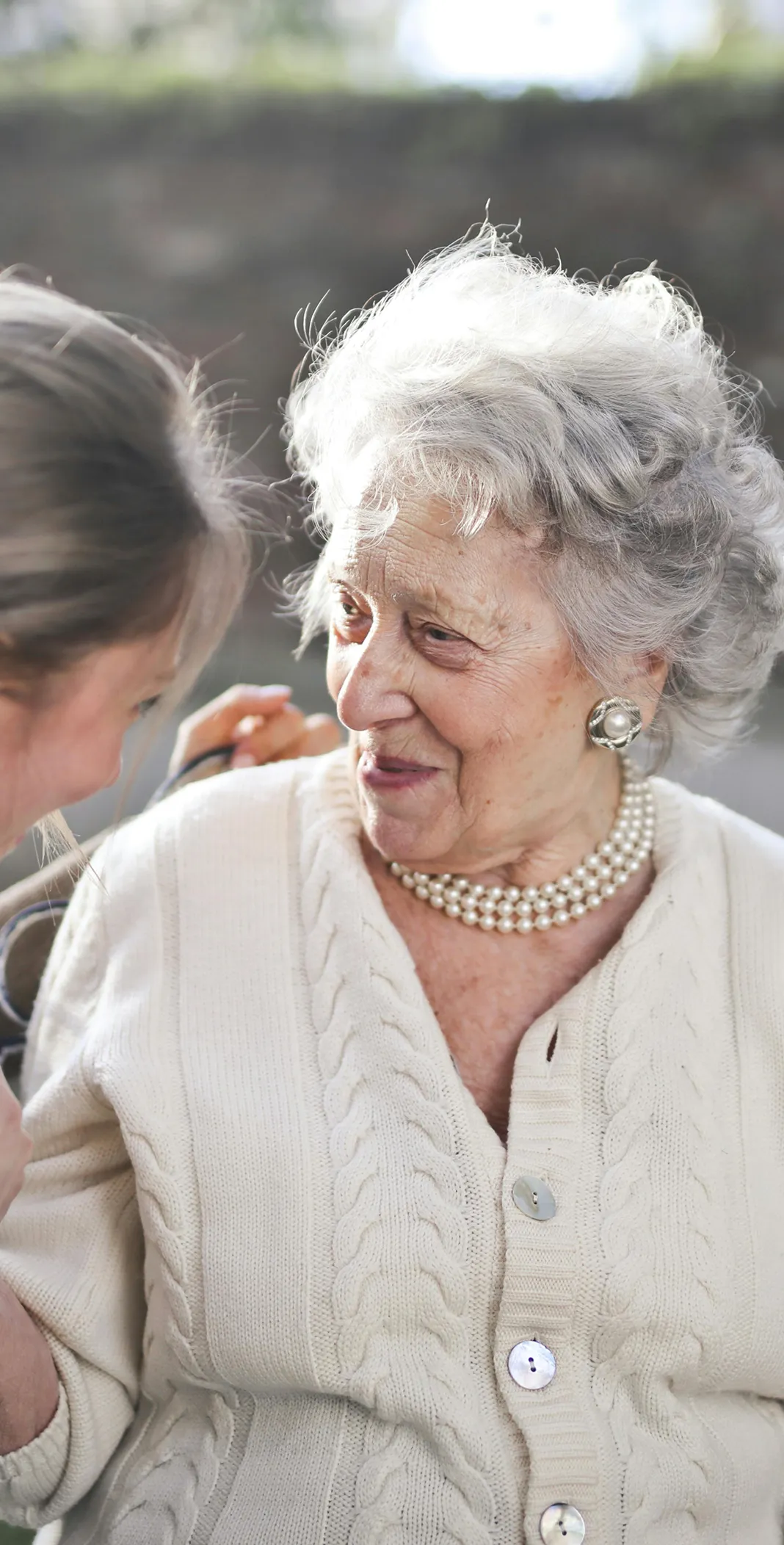 A senior lady smiling and talking with her companion.